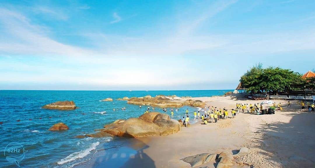 Long Hai Beach's expansive flat sand perfect for camping with colorful tents dotting the pristine coastline 